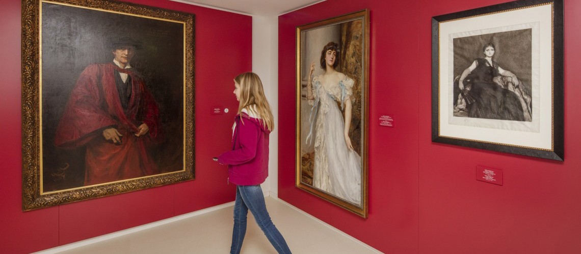 Ein Mädchen betrachtet ein Selbstporträt Herkomers im rot gestrichenen Raum &quot;Porträtmaler der Reichen&quot;