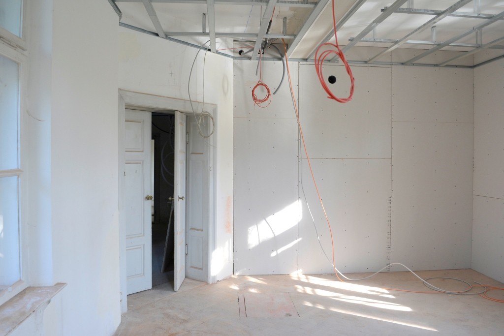 Kabel hängen von der Raumdecke, die Wände sind frisch verschalt.